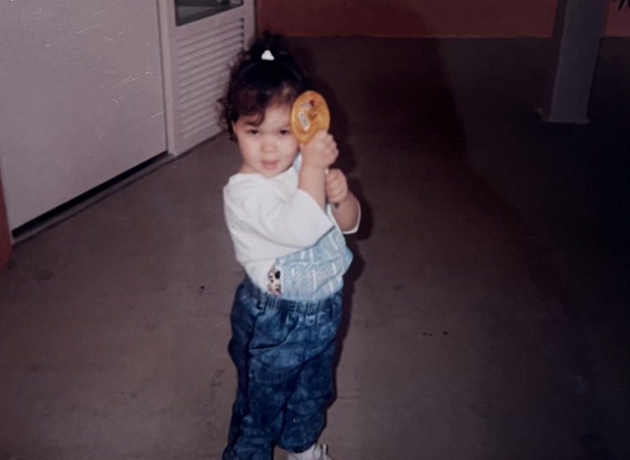 A photo of Britney as a toddler holding a lollipop.