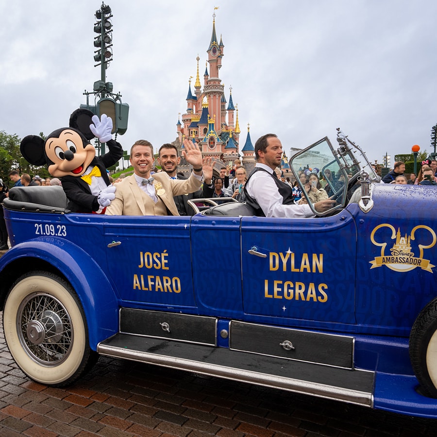 Jose Alfaro and Dylan Legras ride in a parade with Mickey Mouse