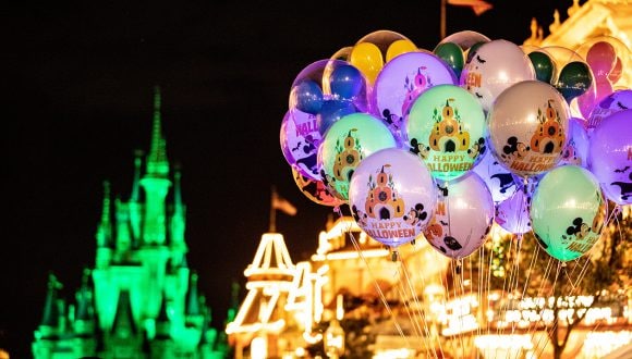 Mickey balloons glow near Cinderella Castle at Mickey’s Not-So-Scary Halloween Party