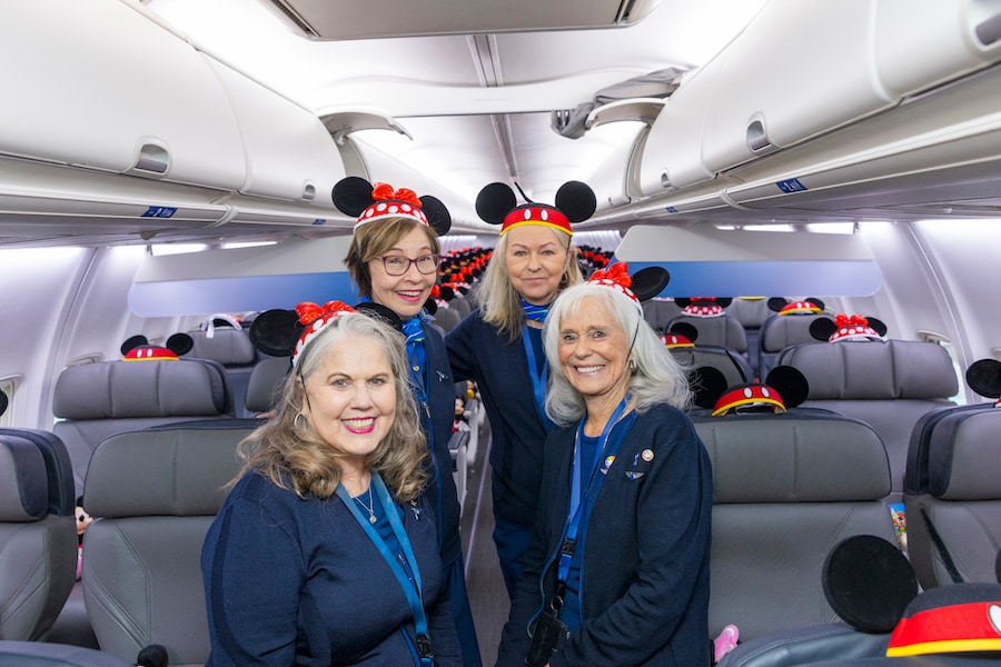 Staff on flight wearing Mickey Ears - Alaska Airlines Reveals Its New Disneyland Resort-Themed Plane “Mickey’s Toontown Express”