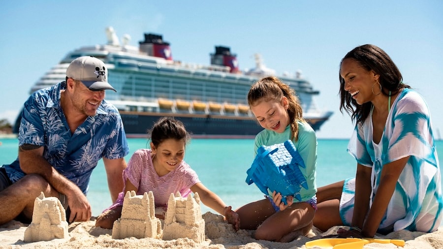 Family playing in the sand on Castaway Cay with a Disney cruise ship in the background