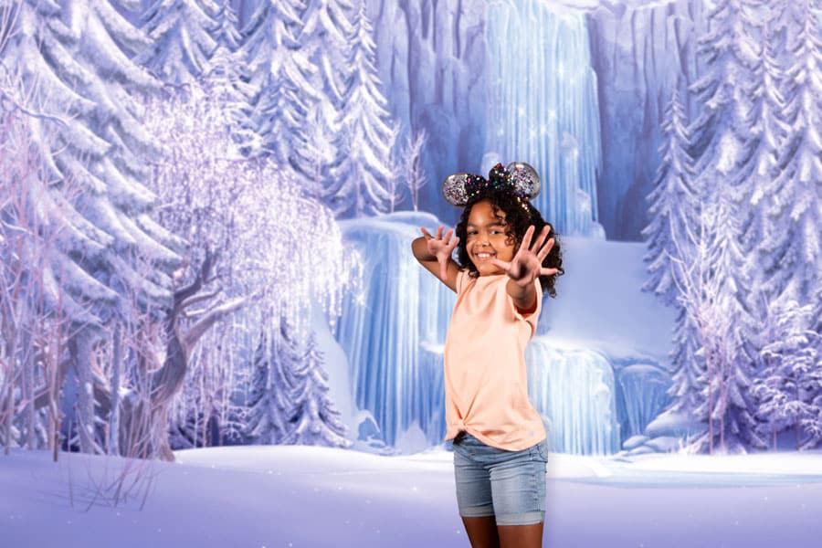 A child posing in the Frozen PhotoPass Studio photo ops in EPCOT 