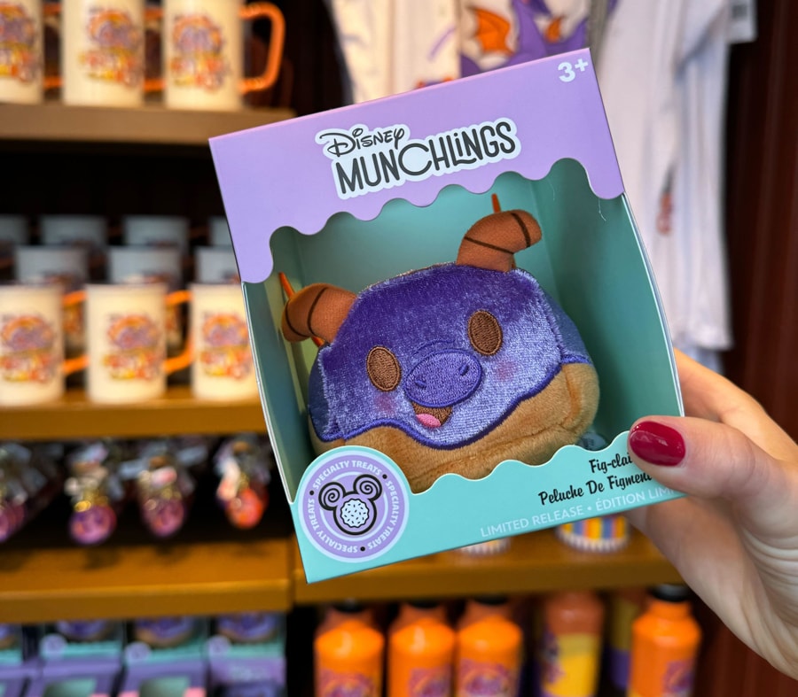 Image of Figment Munchling plush in the shape of an eclair available during 2024 EPCOT Festival of the Arts