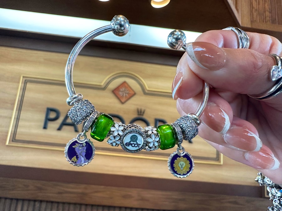 Image of Figment Disney Pandora charm and EPCOT Spaceship Earth Pandora charm on a bracelet