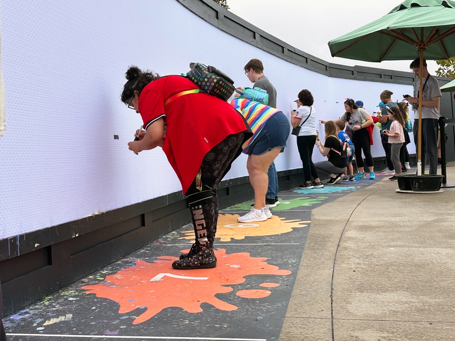 Image of guests painting by number at the Expression Section Paint by Numbers mural during EPCOT Festival of the Arts 2024