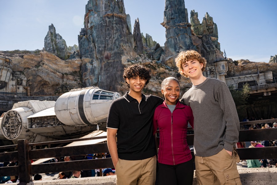 Image of Percy Jackson and the Olympians cast Walker Scobell (Percy), Leah Jeffries (Annabeth) and Aryan Simhadri (Grover Underwood) posing in front of the Millennium Falcon at Star Wars Galaxy's Edge at Disney's Hollywood Studios