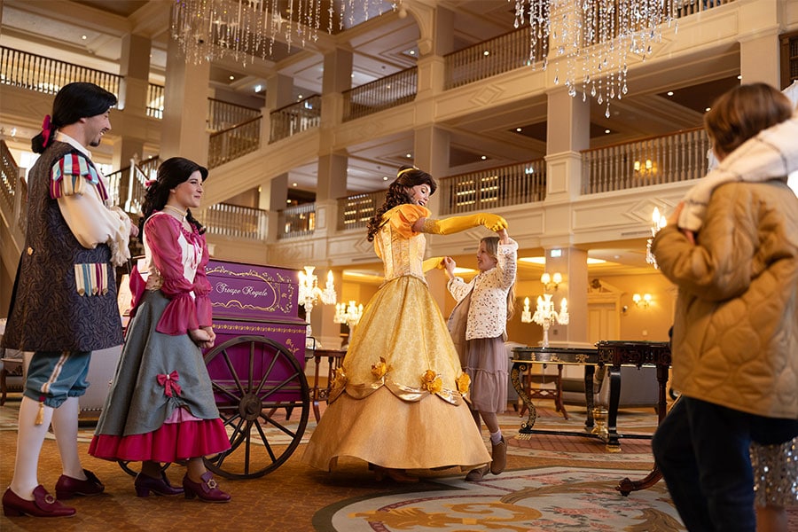 Girl dancing with Belle in the lobby of the Disneyland Hotel at Disneyland Paris