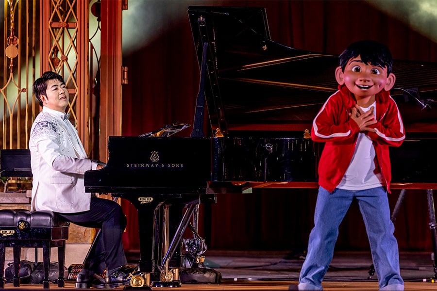 Pianist Lang Lang and Miguel from "Coco" in front of Castle of Magical Dreams at Hong Kong Disneyland