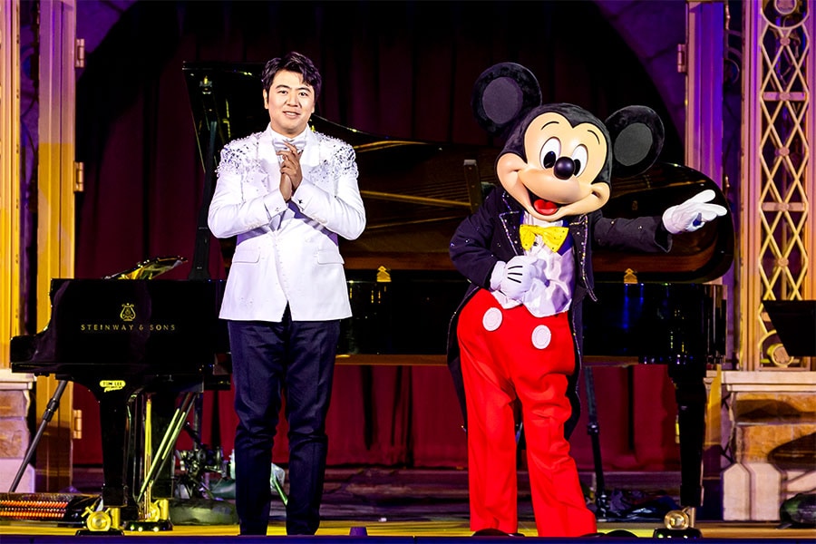Pianist Lang Lang with Mickey Mouse in front of Castle of Magical Dreams at Hong Kong Disneyland