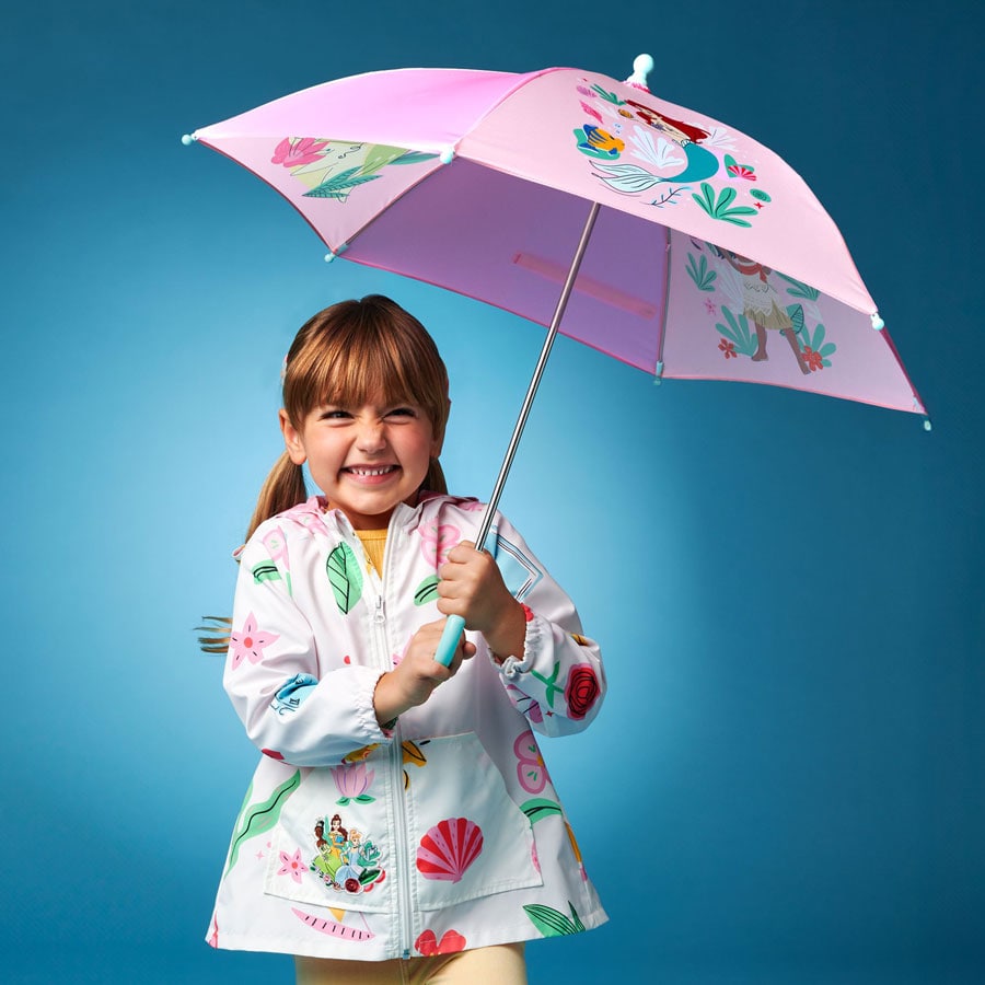 Child wearing Disney Princess hooded rain jackets and umbrellas.