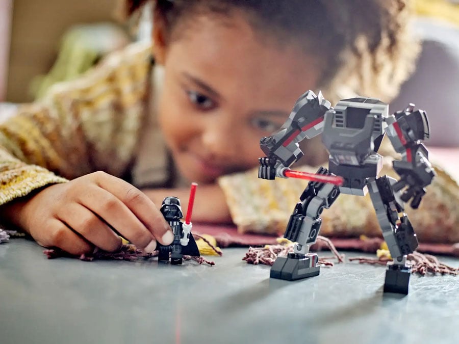 Child playing with LEGO Star Wars Darth Vader Mech