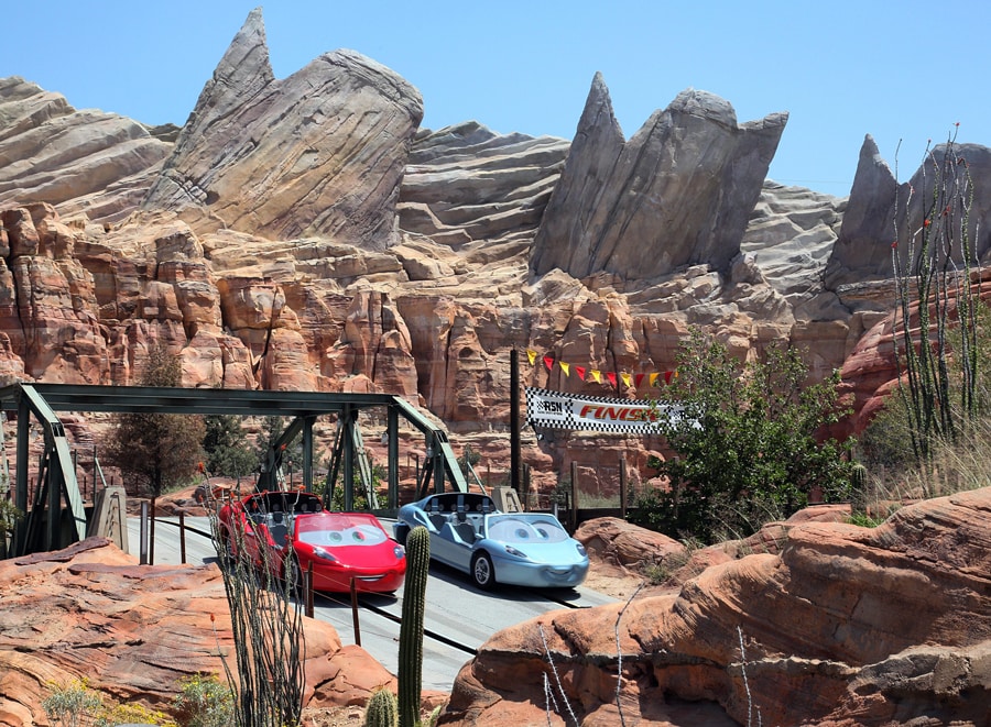 Two cars speed by on Radiator Springs Racers at California Adventure Park