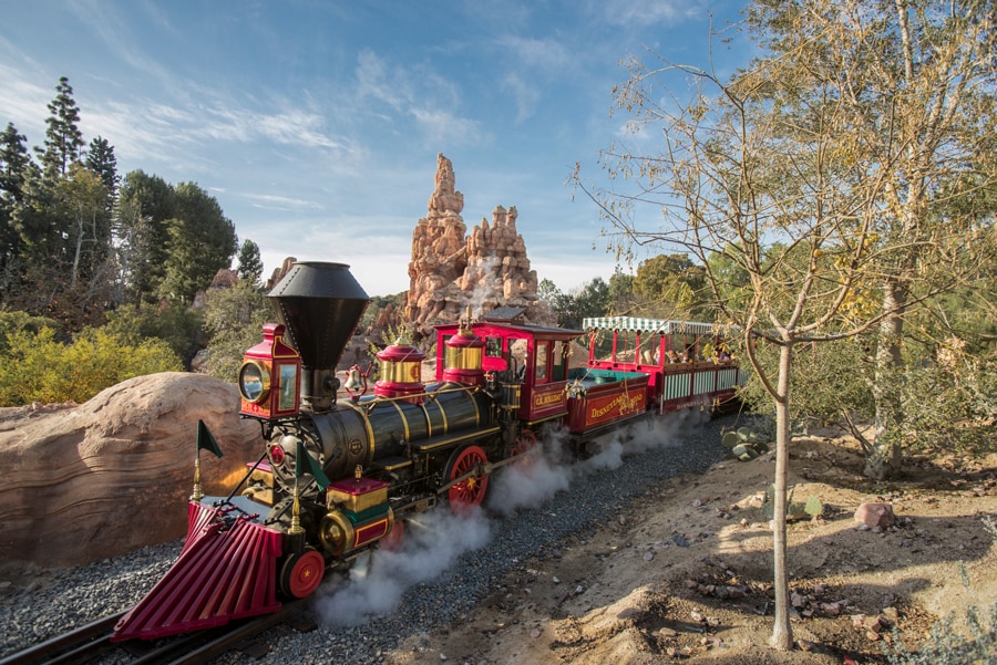 Image of the Disneyland Resort Train is seen along the tracks with Frontierland in the distance.