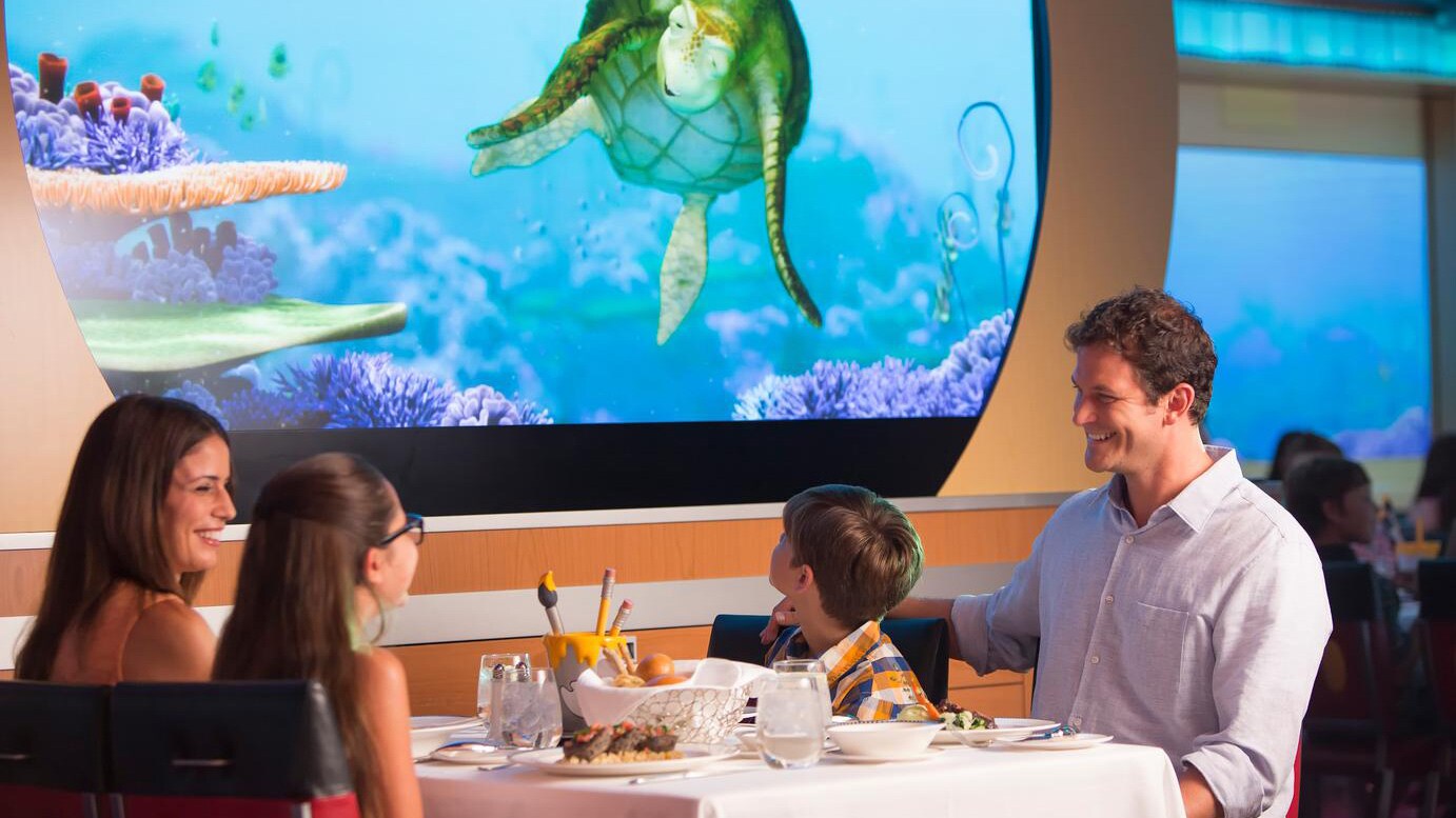Em uma tela animada, Crush, de Procurando Nemo, se aproxima de uma família que janta no Animators Palate.