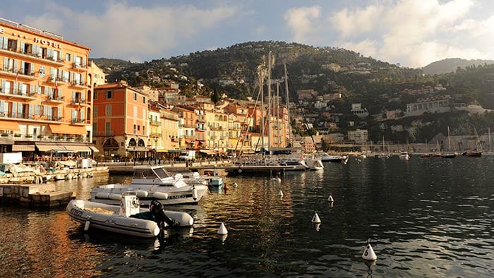 Des bateaux dans une marina prs d'une ville et d'une montagne
