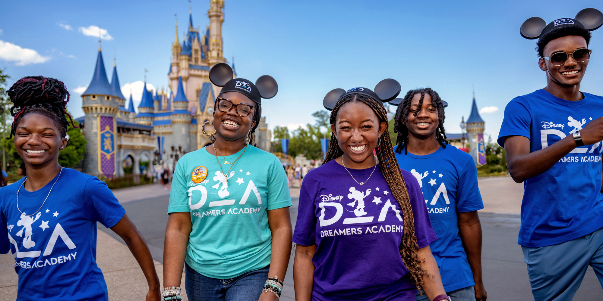 A group of smiling teenagers wearing Disney Dreamers Academy T shirts