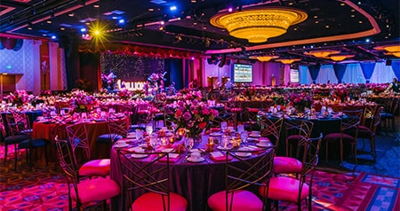 A large ballroom at the Disneyland Hotel with set tables and floral arrangements 