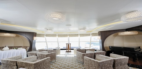 A room bathed in sunlight with chairs and a podium set up for a marriage ceremony