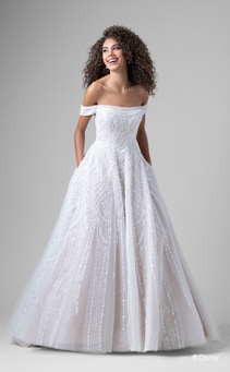 A bride wearing a Jasmine inspired A line gown featuring beading and an off the shoulder neckline