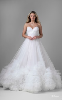 A bride wearing a Rapunzel inspired ball gown featuring a sweetheart neckline and ruffles around the hem