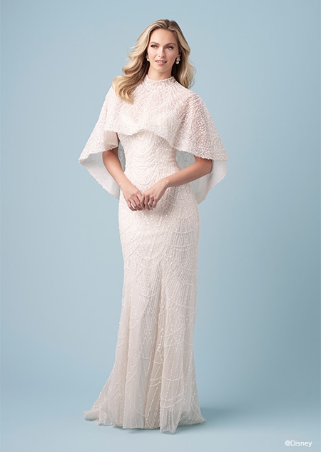 A bride wearing a capelet and a Tiana inspired fit and flare wedding gown featuring beading