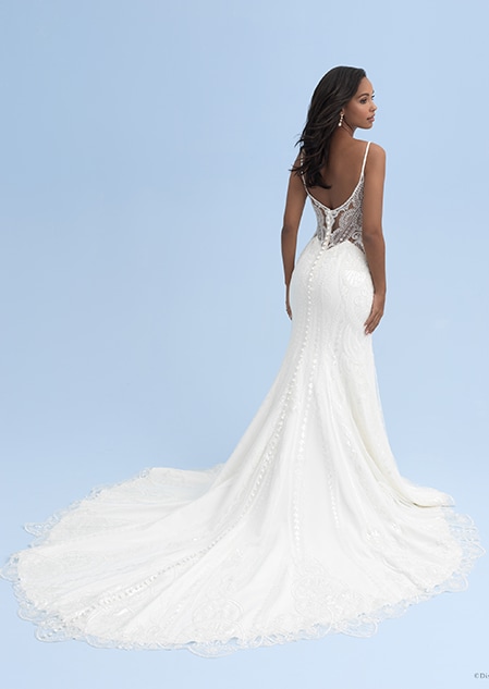 The back of a woman wearing a wedding dress with skinny straps and a lace see thru bodice and a skirt with a long train The back of a woman wearing a wedding dress with skinny straps and a lace see thru bodice and a skirt with a long train