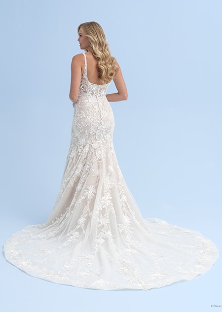 The back view of a bride with long hair wearing a wedding dress with thin straps adorned with crystal flowers The back view of a bride with long hair wearing a wedding dress with thin straps adorned with crystal flowers