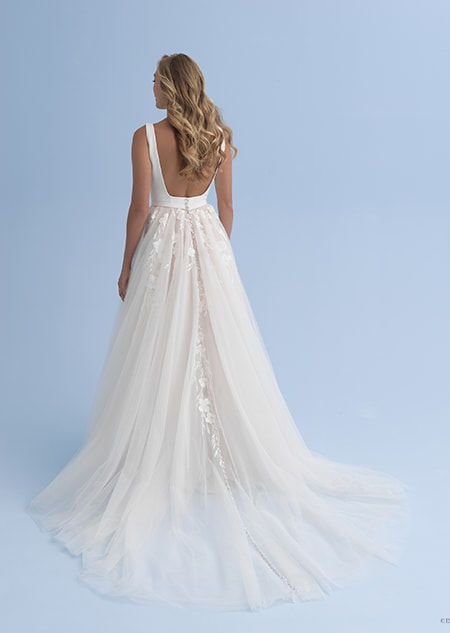 The back view of a bride in a wedding dress with a low back and a skirt adorned with flowers The back view of a bride in a wedding dress with a low back and a skirt adorned with flowers