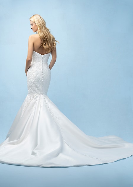 The back of a bride wearing an Ariel inspired mermaid gown featuring beading and a train The back of a bride wearing an Ariel inspired mermaid gown featuring beading and a train