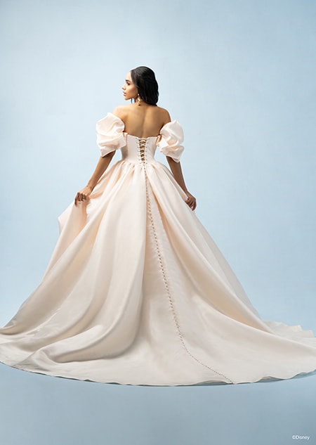 The back of a bride wearing a Belle inspired ball gown featuring off the shoulder sleeves and a train