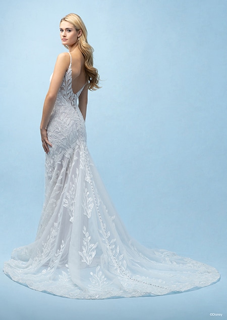 The back of a bride wearing a Rapunzel inspired sheath gown featuring a low back, lace detail and a train