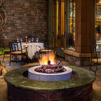 An outdoor dining area with a fire pit at Napa Rose in Disney's Grand Californian Hotel & Spa