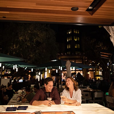 A couple smiling and enjoying beverages at Naples Ristorante e Bar