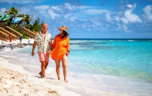A couple walking along a beach at Disney Lookout Cay at Lighthouse Point