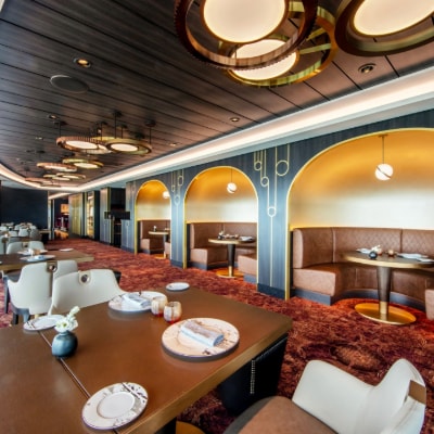 Tables, chairs, and table settings in Palo Steakhouse on board the Disney Wish cruise ship 