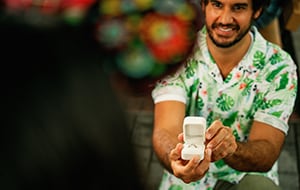 A man proposing on one knee with a ring in an open ring box