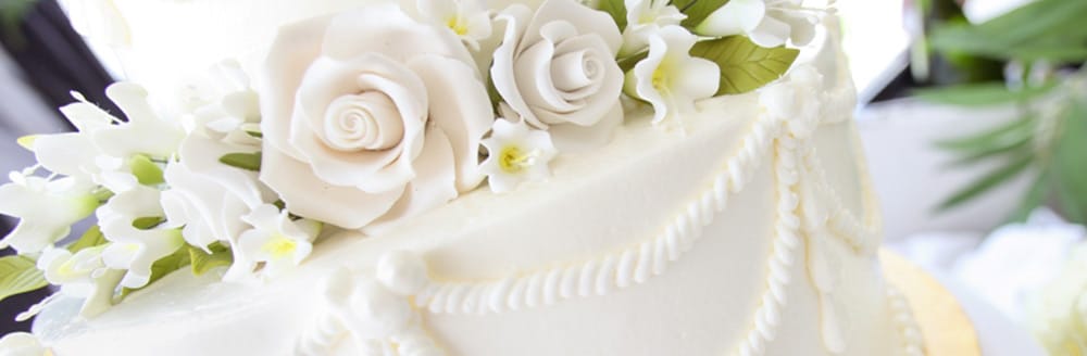 A wedding cake topped with fondant roses and flowers