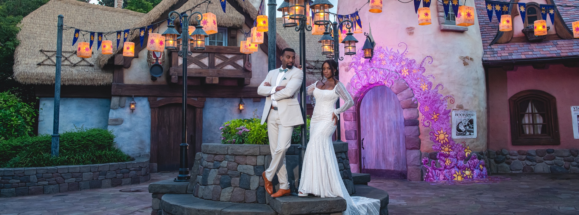 A wedding couple posing amid whimsical Tangled themed lanterns and buildings at Magic Kingdom park A wedding couple posing amid whimsical Tangled themed lanterns and buildings at Magic Kingdom park