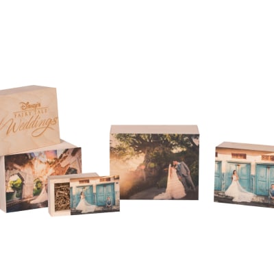 Keepsake boxes with wedding photo prints on the covers, and one reading ‘Disney’s Fairy Tale Weddings’ 
