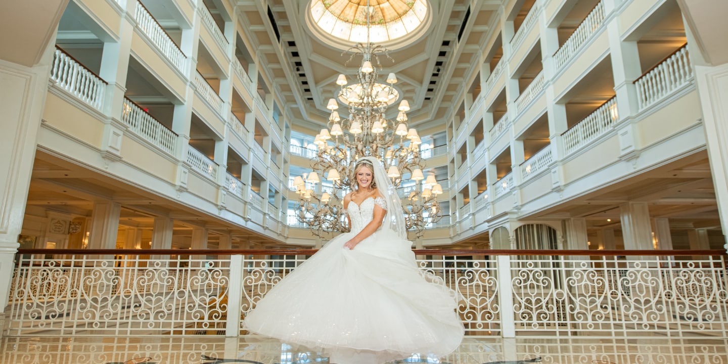 A bride twirling in her wedding gown in the grand lobby of Disney's Grand Floridian Resort & Spa