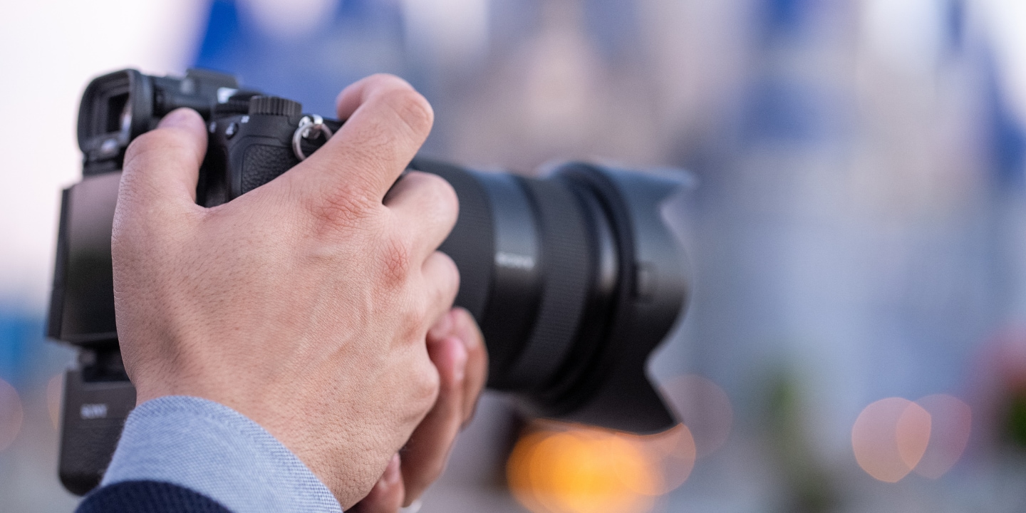 The hands of a photographer holding a professional camera	