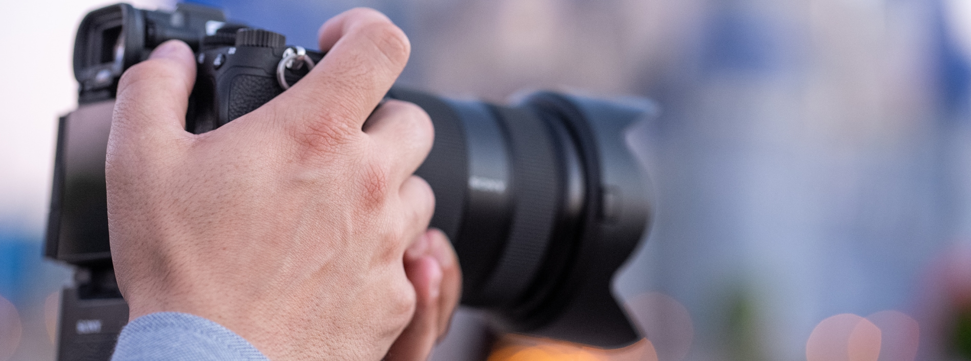 The hands of a photographer holding a professional camera	
