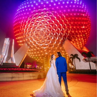 A wedding couple posing near Spaceship Earth at EPCOT