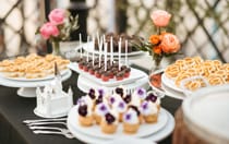 A dessert table with waffle sandwiches and chocolate covered Mickey Mouse cake pops 