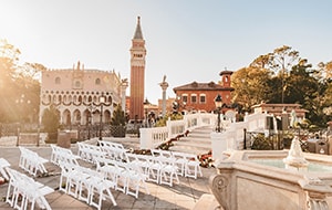 Chairs set up at a wedding venue near a fountain, bridge and tower at Italy Isola in Epcot Chairs set up at a wedding venue near a fountain, bridge and tower at Italy Isola in Epcot