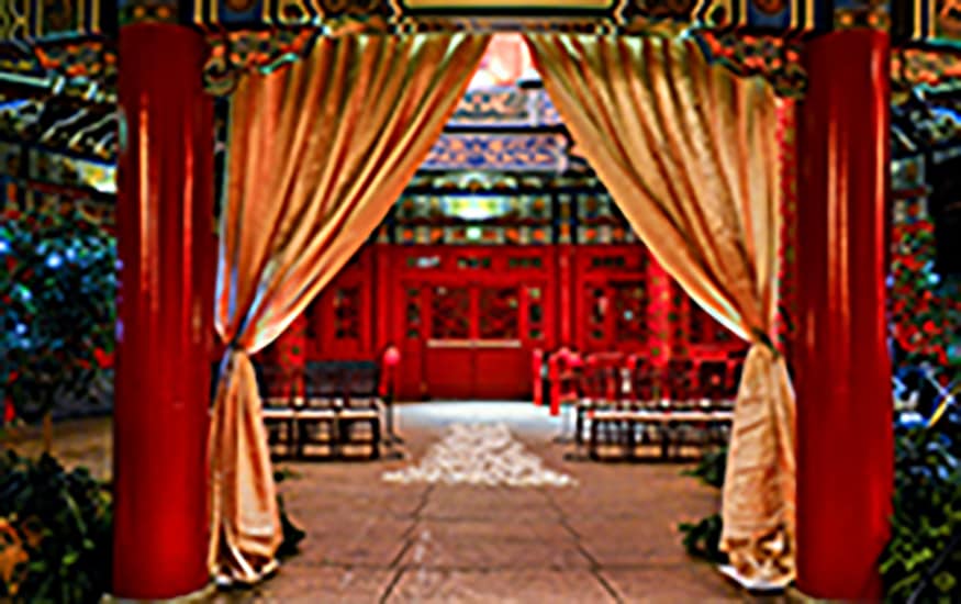 Rows of chairs set up for a wedding beneath a covered courtyard at the China Pavilion in EPCOT