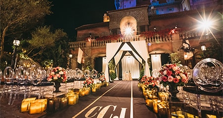 An outdoor wedding ceremony venue with chairs, flowers and an altar set up in front of the Hollywood Tower Hotel