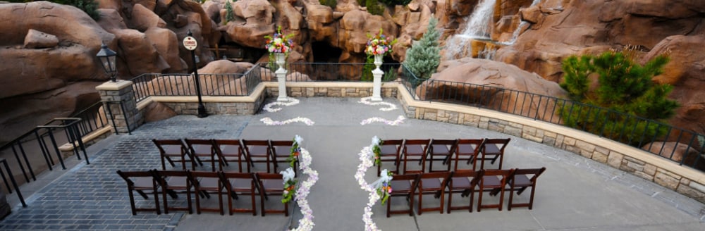 Two sections of folding chairs facing an altar in front of a waterfall