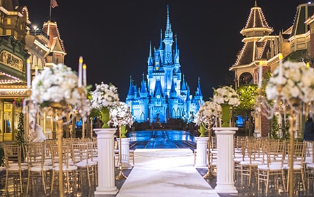 Rows of chairs and flowers arranged for a wedding ceremony with a castle as the backdrop