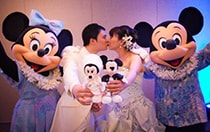 Mickey and Minnie celebrate as a bride and groom kiss